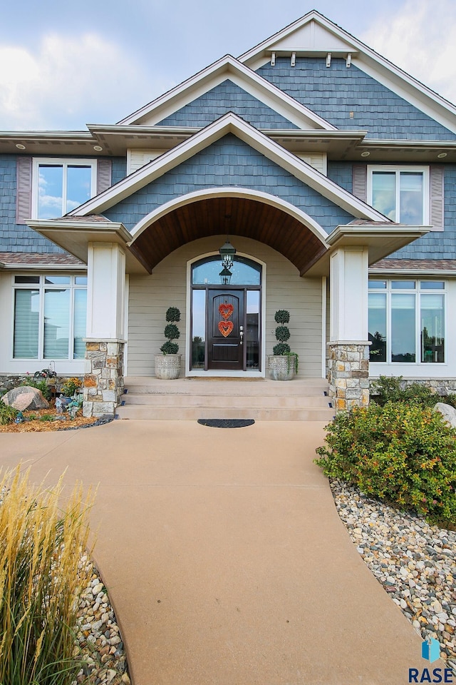 entrance to property with stone siding and a porch