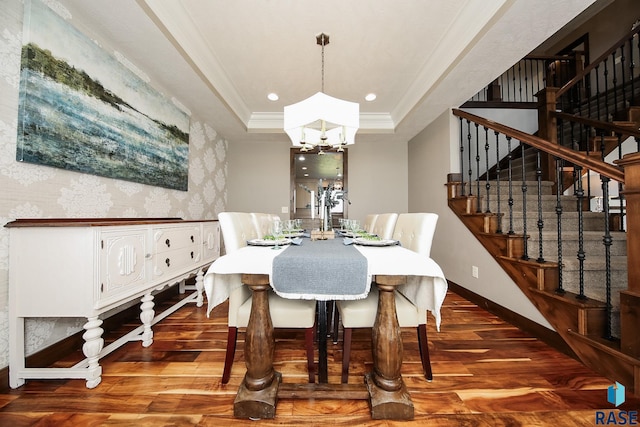 dining room featuring a tray ceiling, a notable chandelier, wood finished floors, and ornamental molding