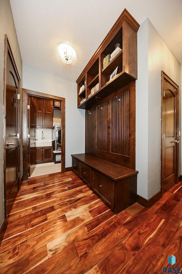 mudroom with dark wood-style floors and baseboards