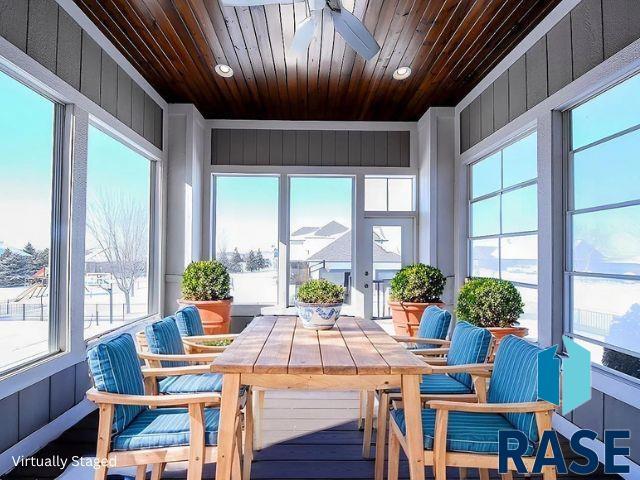 sunroom / solarium with wood ceiling and a ceiling fan