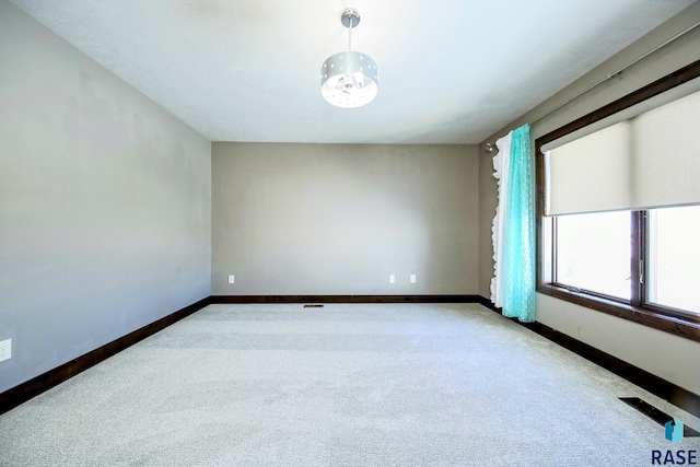 carpeted empty room with visible vents and baseboards