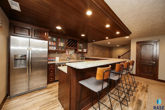 kitchen featuring glass insert cabinets, recessed lighting, visible vents, and stainless steel appliances