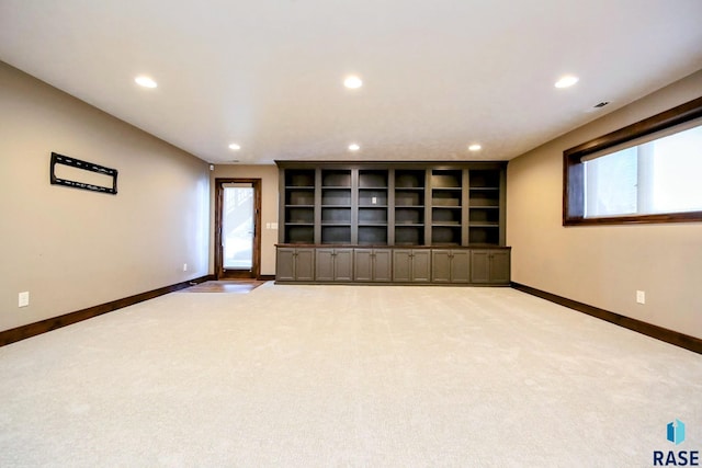 unfurnished living room with recessed lighting, light colored carpet, and baseboards