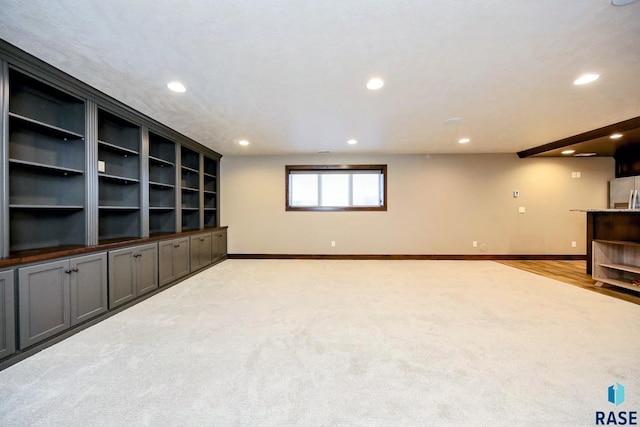 unfurnished living room with recessed lighting, light colored carpet, and baseboards