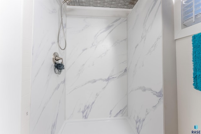 full bath featuring a marble finish shower