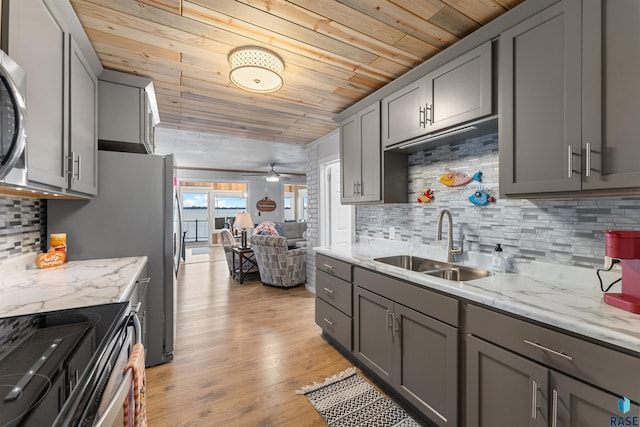 kitchen with a sink, light wood-style floors, a ceiling fan, and gray cabinets