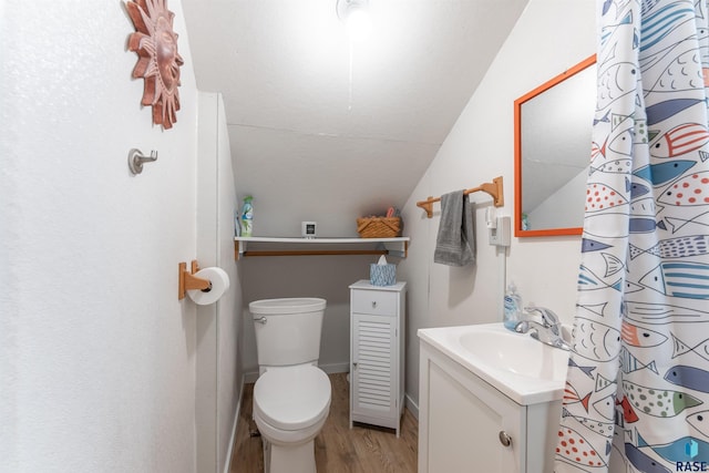 full bathroom with toilet, wood finished floors, vanity, and vaulted ceiling