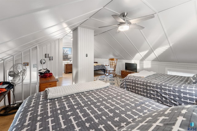 bedroom with ceiling fan, lofted ceiling, and wood finished floors