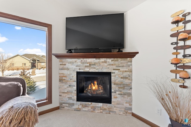 carpeted living room with a wealth of natural light, a fireplace, and baseboards