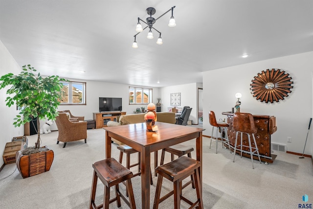 dining room featuring visible vents, baseboards, and light carpet