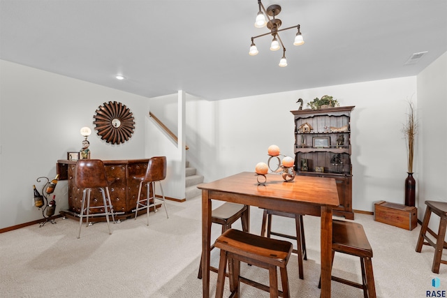 carpeted dining area with stairs, baseboards, and visible vents