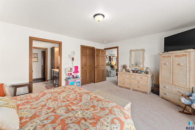 bedroom with light colored carpet and ensuite bath