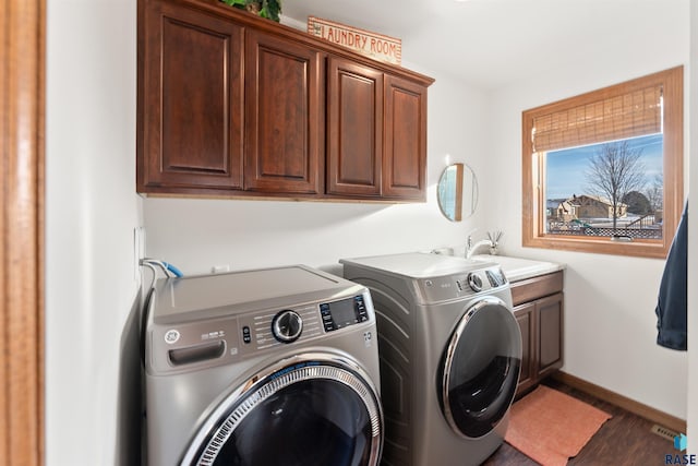 clothes washing area featuring baseboards, wood finished floors, cabinet space, independent washer and dryer, and a sink