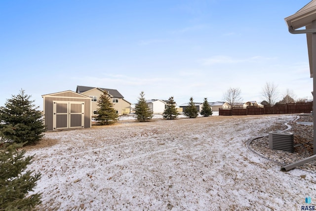 view of yard with an outbuilding, a storage unit, and fence