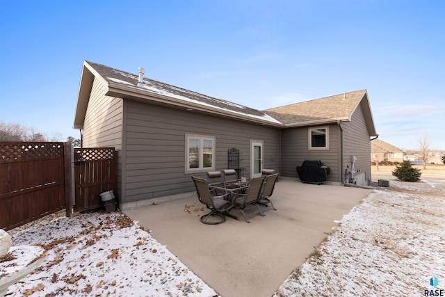 back of property featuring a patio, outdoor dining area, fence, and a shingled roof