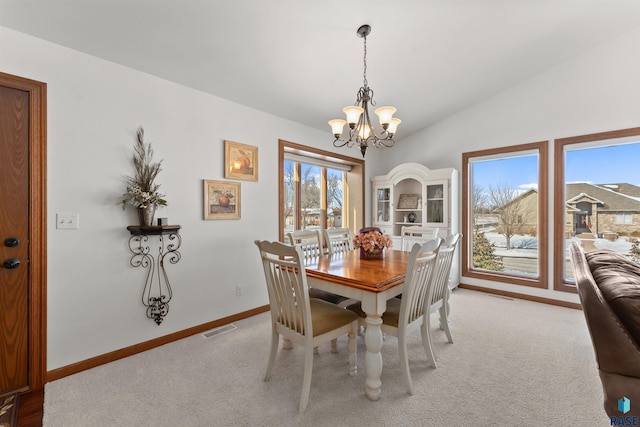 dining area featuring light carpet, a notable chandelier, visible vents, and vaulted ceiling