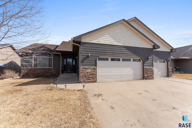 view of front of property with stone siding, an attached garage, and concrete driveway