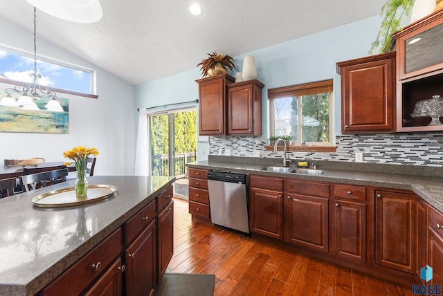 kitchen featuring a sink, backsplash, dark wood-style floors, dishwasher, and vaulted ceiling