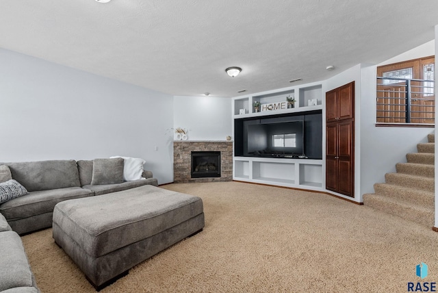 living area with built in shelves, stairs, carpet floors, a stone fireplace, and a textured ceiling