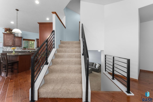 staircase featuring recessed lighting, wood finished floors, and baseboards