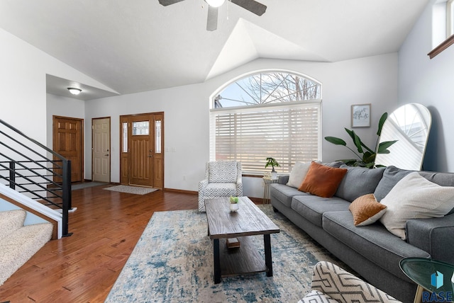 living area with vaulted ceiling, stairway, wood finished floors, and a wealth of natural light