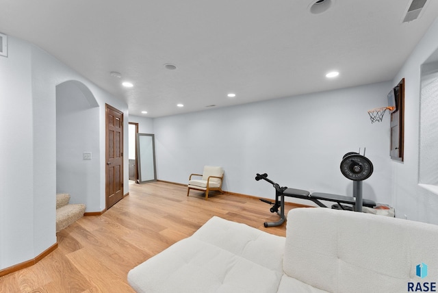 exercise area with recessed lighting, arched walkways, light wood finished floors, and baseboards