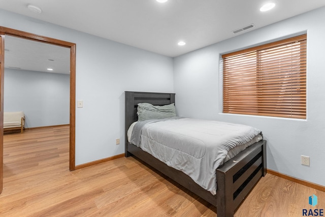 bedroom featuring visible vents, baseboards, and light wood-style flooring