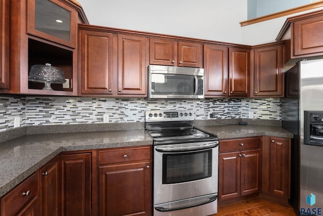 kitchen with dark countertops, stainless steel appliances, and tasteful backsplash