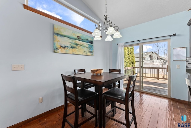 dining space featuring baseboards, an inviting chandelier, and wood finished floors