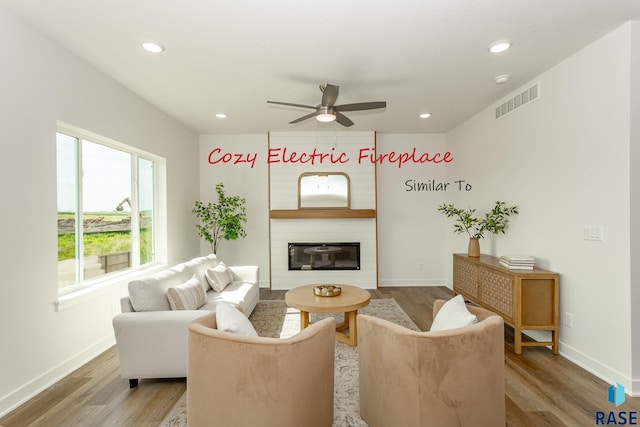 living area with visible vents, a large fireplace, light wood-type flooring, recessed lighting, and a ceiling fan