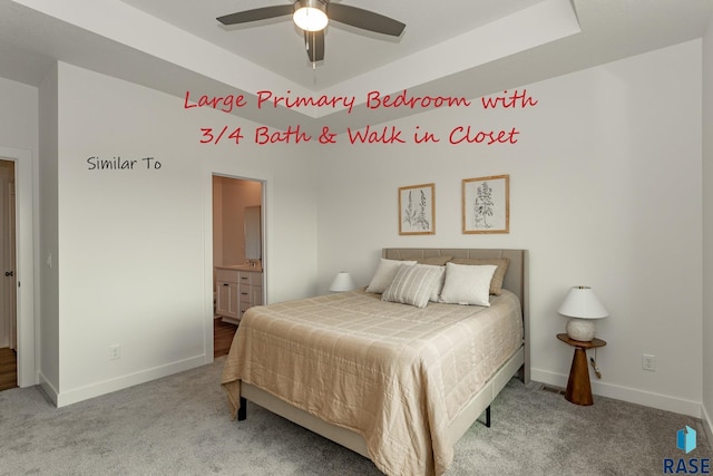 bedroom featuring a raised ceiling, ensuite bathroom, baseboards, and carpet floors