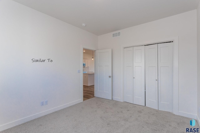 unfurnished bedroom with a closet, visible vents, baseboards, and carpet