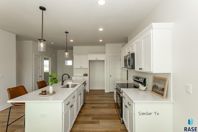 kitchen featuring backsplash, a breakfast bar area, stainless steel appliances, and a sink