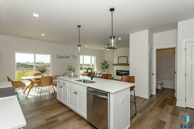 kitchen featuring a sink, white cabinets, light wood-style floors, and stainless steel dishwasher