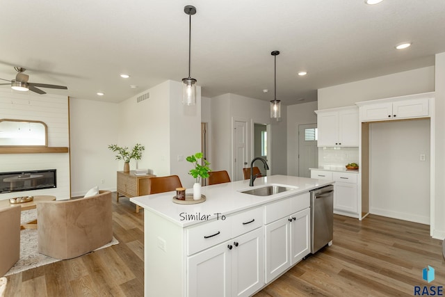 kitchen with visible vents, dishwasher, light wood-style floors, and a sink