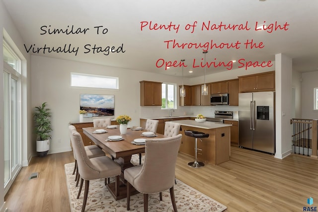 dining area featuring light wood-style flooring, baseboards, and visible vents