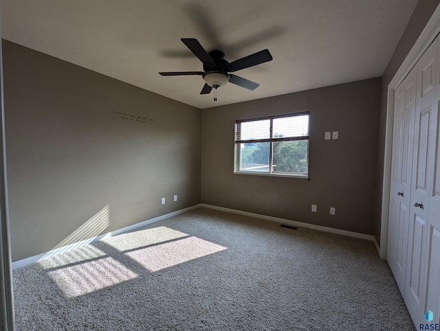 unfurnished bedroom featuring a ceiling fan, carpet flooring, baseboards, and a closet