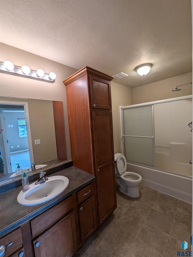 full bathroom with vanity, a textured ceiling, toilet, and enclosed tub / shower combo