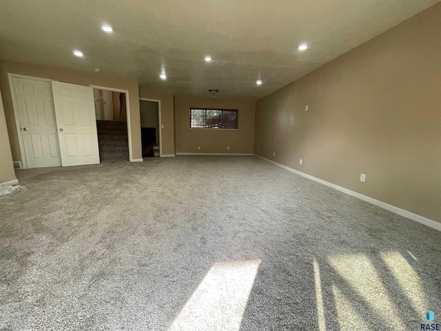 carpeted empty room featuring recessed lighting, baseboards, and stairs