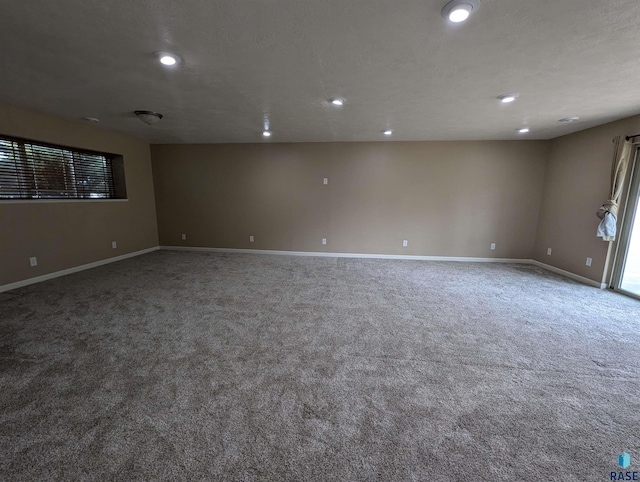 carpeted spare room featuring recessed lighting, baseboards, and a textured ceiling