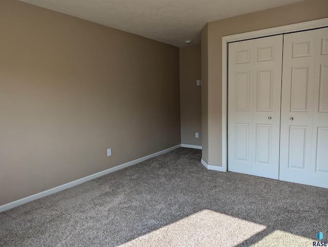 unfurnished bedroom featuring a closet, baseboards, and carpet