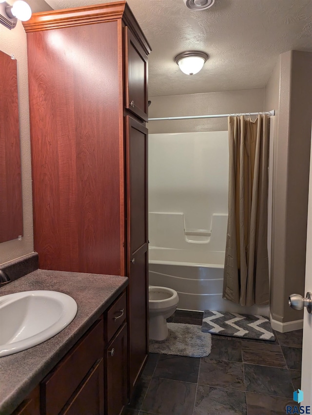 bathroom with vanity, a textured ceiling, shower / bath combo, stone finish flooring, and toilet