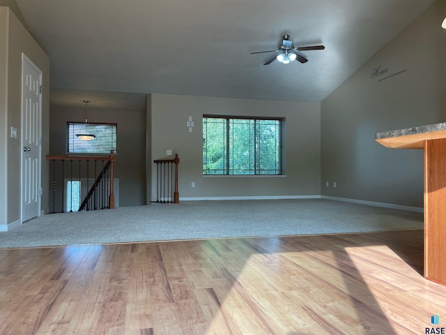 unfurnished living room featuring baseboards, wood finished floors, a ceiling fan, and vaulted ceiling