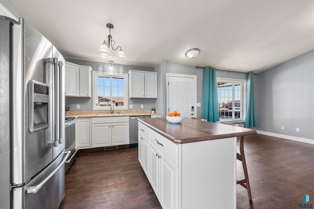 kitchen featuring a kitchen bar, plenty of natural light, appliances with stainless steel finishes, and a sink