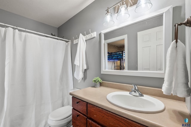 bathroom featuring a shower with shower curtain, toilet, and vanity