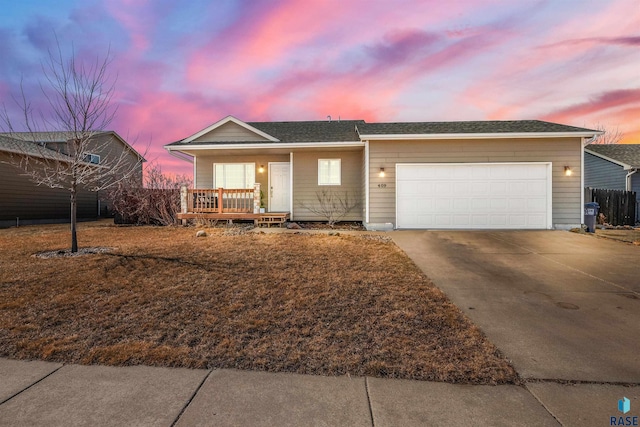 ranch-style house with a garage, fence, covered porch, and driveway