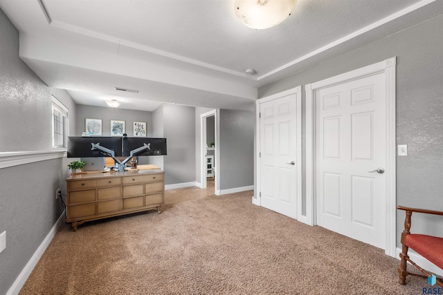 interior space featuring visible vents, baseboards, carpet, and a textured wall