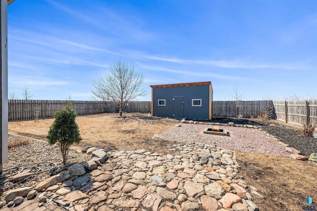 view of yard featuring an outbuilding, a storage unit, and a fenced backyard