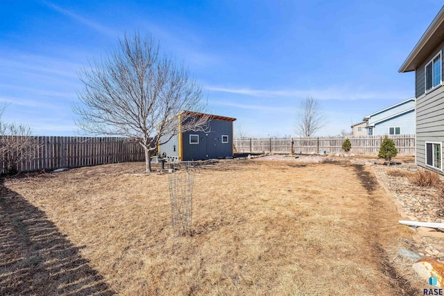 view of yard featuring a shed, an outdoor structure, and a fenced backyard