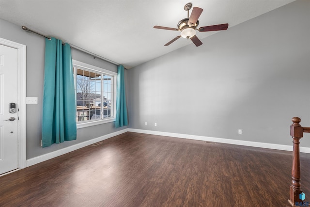 empty room with visible vents, baseboards, vaulted ceiling, wood finished floors, and a ceiling fan